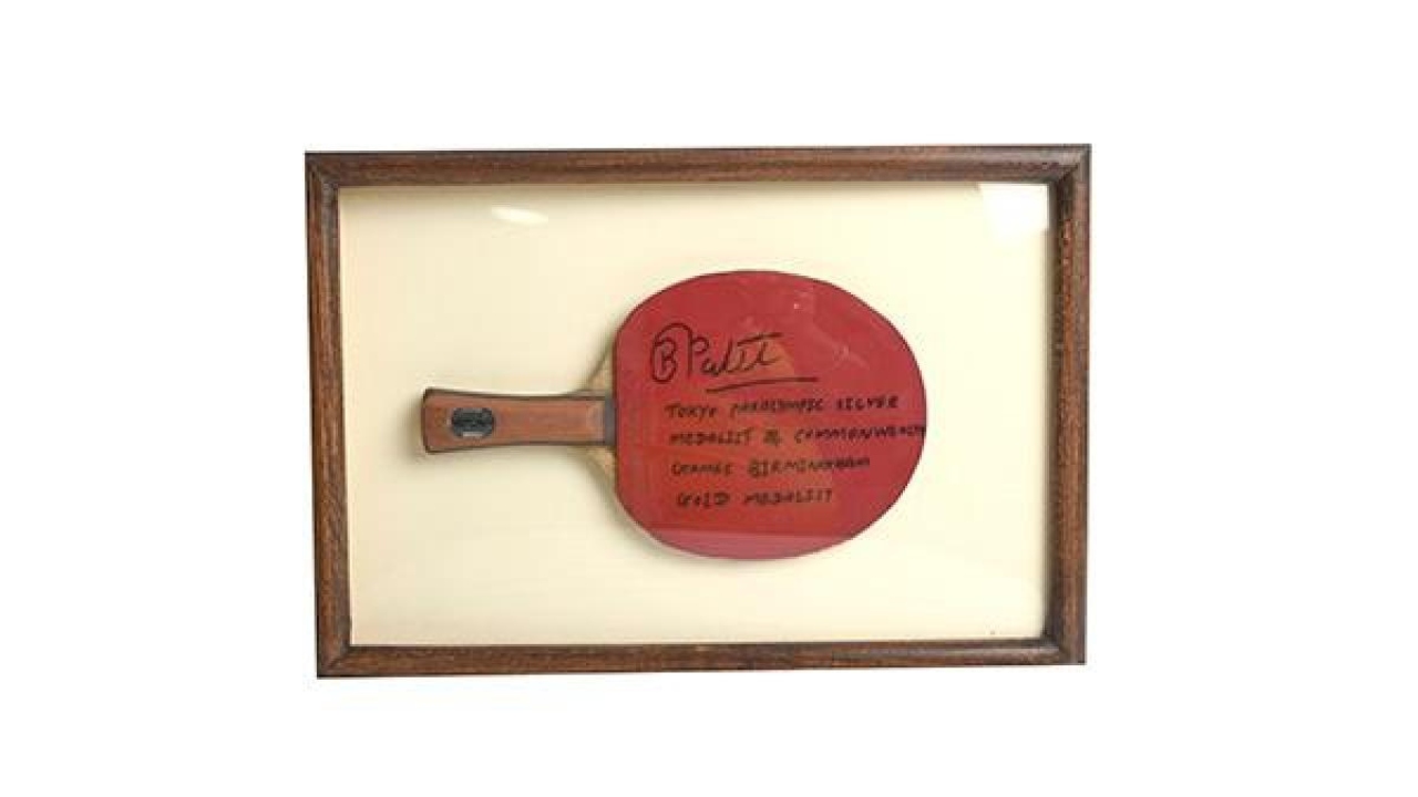 A red table tennis racket autographed by CommonWealth Games 2022 gold medallist Bhavina Patel. Credit: Special Arrangement
