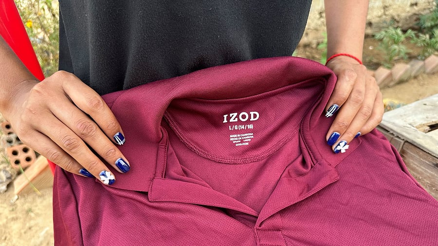 <div class="paragraphs"><p>A former inmate at Correctional Center 2, a women's prison on the outskirts of Phnom Penh, holds a polo shirt with an IZOD label that she said was made in a factory on prison grounds, at an undisclosed location in Cambodia. </p></div>