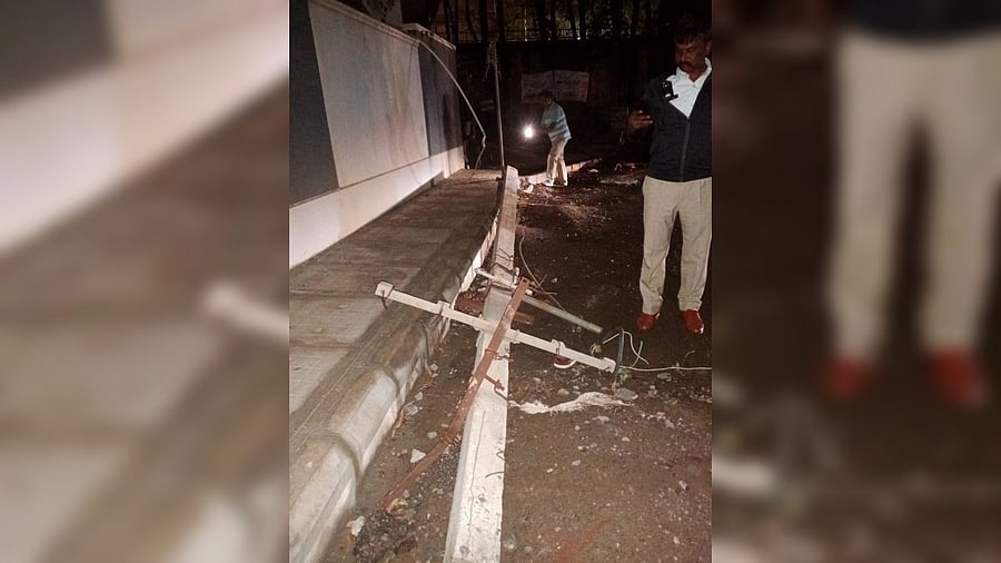 <div class="paragraphs"><p>Police inspect the electric pole that came crashing down on a 23-year-old in Devarabisanahalli. </p></div>