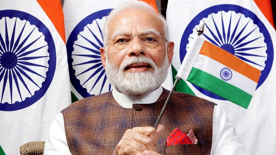 <div class="paragraphs"><p>PM Narendra Modi waves the Indian flag while watching the telecast of Chandrayaan-3's successful soft landing on the Moon’s surface. </p></div>