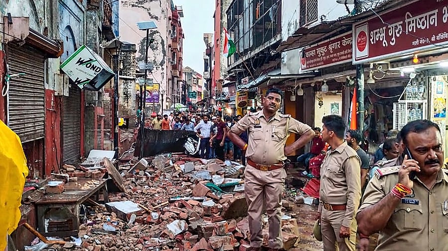 <div class="paragraphs"><p>Police personnel stand on the debris of a building that collapsed near Sri Bankey Bihari temple, in Vrindavan, Tuesday, Aug 15, 2023. </p></div>