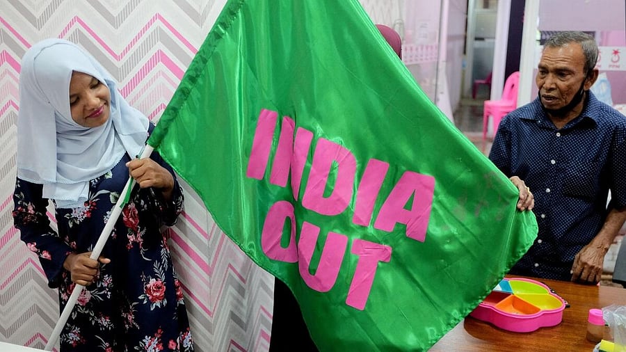 <div class="paragraphs"><p>A Progressive Party of Maldives worker poses with an "India Out" flag in Male, Maldives.</p></div>