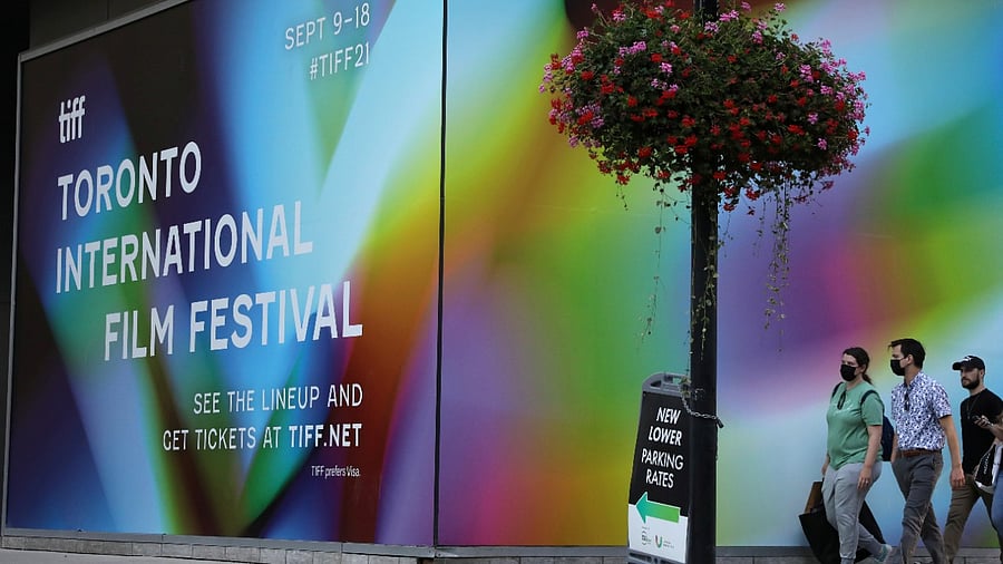 <div class="paragraphs"><p>People pass a large mural at the Toronto International Film Festival. </p></div>