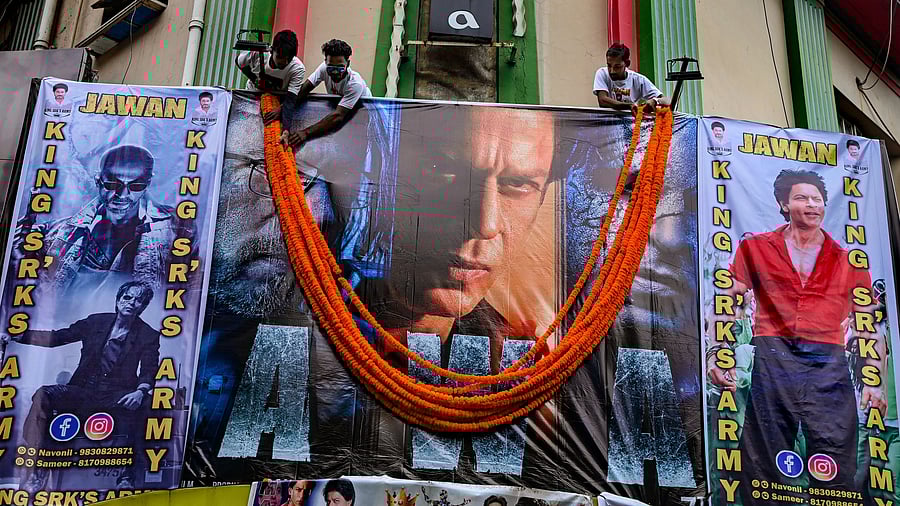 <div class="paragraphs"><p>Fans of actor Shah Rukh Khan hang garlands on the poster of his newly released movie Jawan at a cinema hall in Kolkata.</p></div>