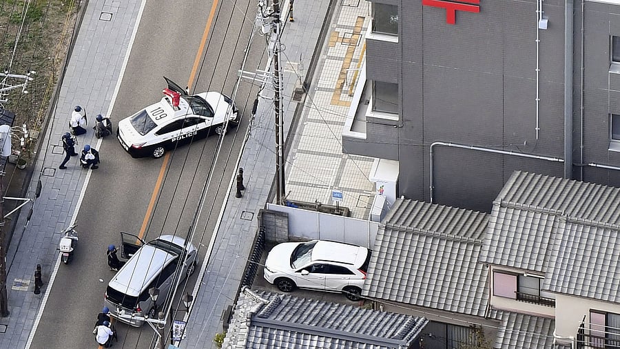 <div class="paragraphs"><p>Police officers take cover behind cars outside the post office where a suspected gunman has taken people hostage after injuring two at a hospital, in Warabi, Saitama Prefecture, Japan October 31, 2023, in this photo taken by Kyodo. </p></div>