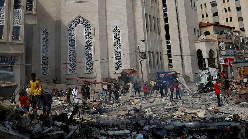 <div class="paragraphs"><p>Palestinians walks near the rubbles in the aftermath of Israeli strikes in in Khan Younis, southern Gaza Strip. </p></div>