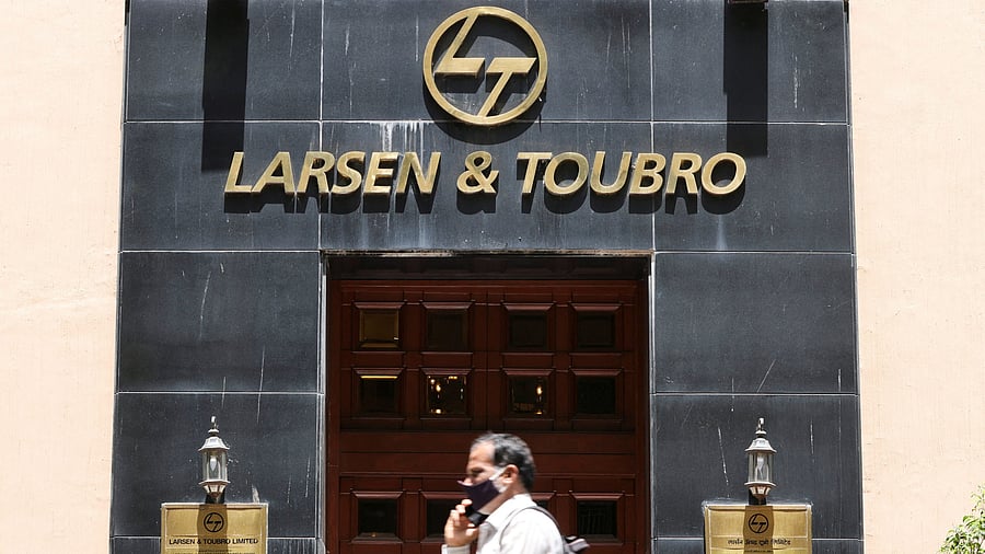 <div class="paragraphs"><p>A man walks past the Larsen &amp; Toubro logo.</p></div>