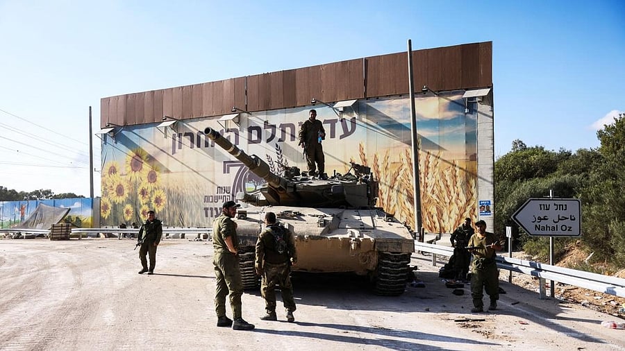 <div class="paragraphs"><p>Israeli soldiers gather on and around a tank near Israel's border with the Gaza Strip. </p></div>