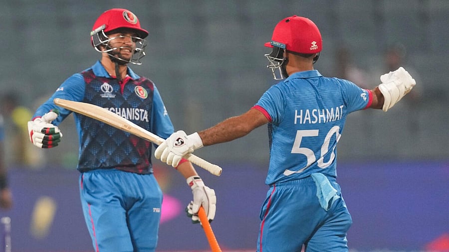 <div class="paragraphs"><p>Afghanistan's batter Azmatullah Omarzai with teammate Hashmatullah Shahidi celebrates after his half-century during the ICC Men's Cricket World Cup 2023 match between Sri Lanka and Afghanistan.</p></div>