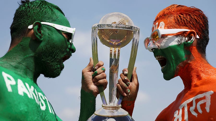 <div class="paragraphs"><p>Cricket fans, Arun Haryani pose for a photograph with a replica trophy after painting their bodies in the Indian and Pakistani national flag colours, ahead of the match between India and Pakistan in the ICC World Cup, in Ahmedabad, India, October 11, 2023. </p></div>