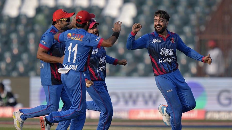 <div class="paragraphs"><p>Afghanistan's Rashid Khan celebrates with teammates after taking the wicket of Sri Lanka's Dasun Shanaka</p></div>