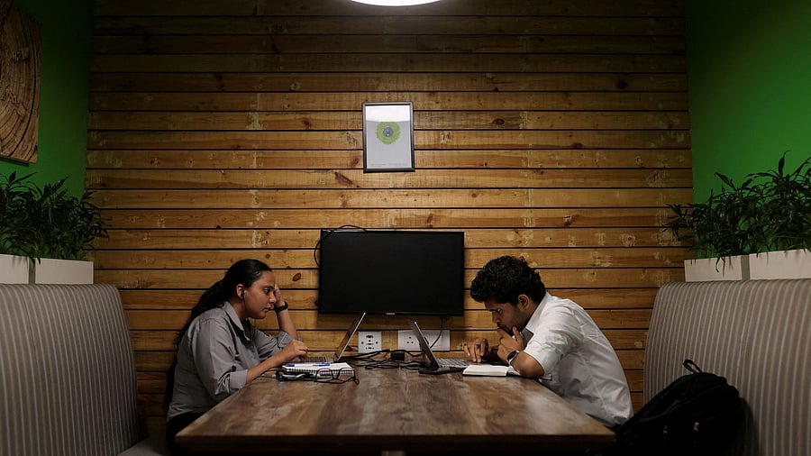 <div class="paragraphs"><p>People sit and work on their laptops at Deloitte's office in Gurugram. </p></div>