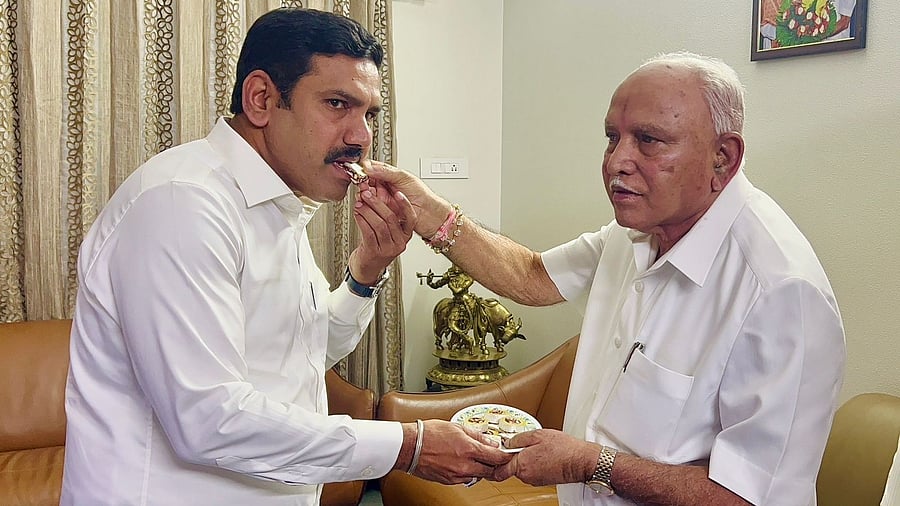 <div class="paragraphs"><p>Former Chief Minister B S Yediyurappa offers sweets to his son B Y Vijayendra, on the latter's appointment as the BJP's Karnataka president, in Bengaluru on Friday. </p></div>