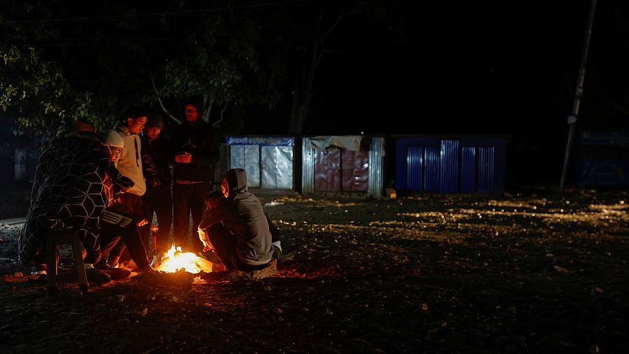 <div class="paragraphs"><p>People sit beside the fire to keep them warm as they spend the night in an open space, after an earthquake at Khalanga in Jajarkot, Nepal November 4, 2023. </p></div>