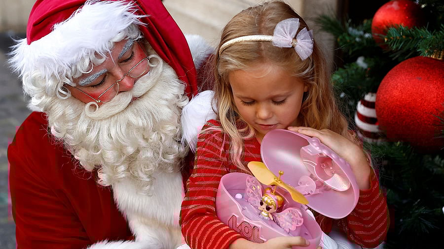 <div class="paragraphs"><p>A person dressed as Santa helps five-year-old Echo Pollicott with the LOL MagicFlyer outside Hamleys toy store.</p></div>