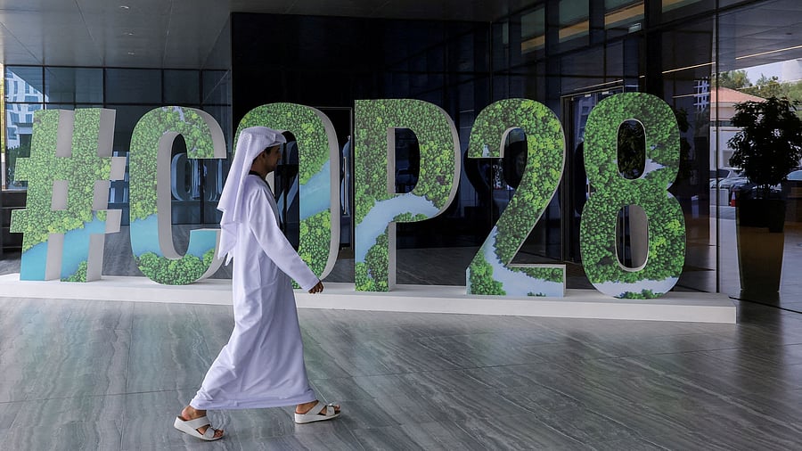 <div class="paragraphs"><p> A person walks past a "#COP28" sign in Abu Dhabi, United Arab Emirates.</p></div>