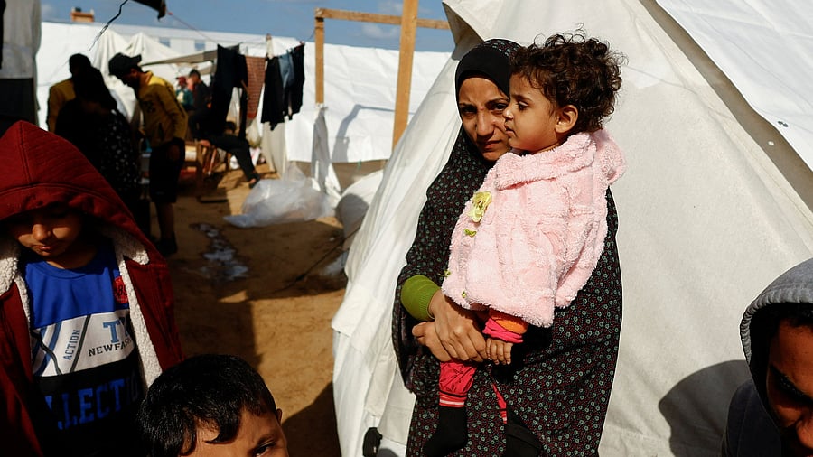 <div class="paragraphs"><p>A displaced Palestinian woman holds a child, amid the ongoing conflict between Israel and Palestinian Islamist group Hamas, in a tent camp in Khan Younis in the southern Gaza Strip, November 20, 2023. </p></div>