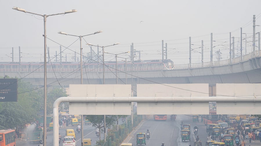<div class="paragraphs"><p>A metro train runs on its track as vehicles ply on a road amid low visibility due to smog, near Anand Vihar metro station in New Delhi, Monday, Nov. 13, 2023. The national capital recorded a jump in pollution levels and a smoky haze returned on Monday following Diwali. </p></div>