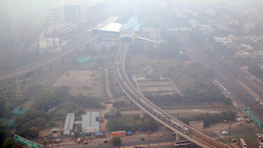 <div class="paragraphs"><p>A metro train runs on its track amid smog, in Noida.</p></div>