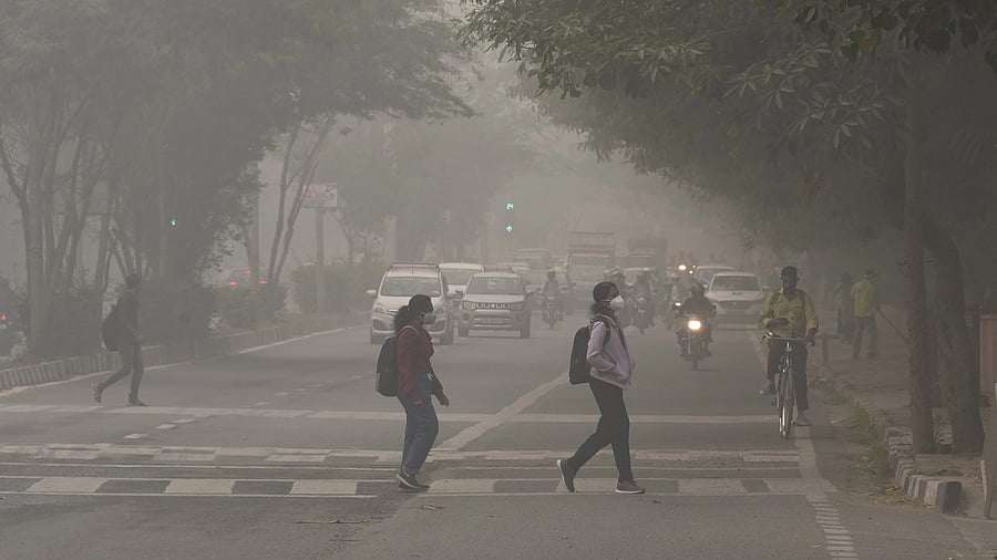 <div class="paragraphs"><p>New Delhi: Students wearing anti-pollution masks cross a road amid hazy weather conditions, in New Delhi. </p></div>