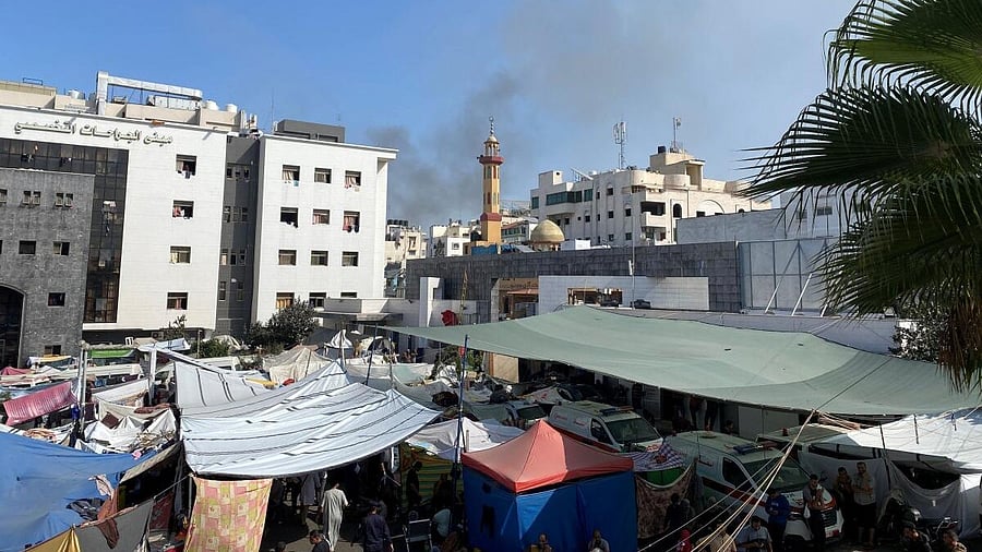 <div class="paragraphs"><p>Smoke rises as displaced Palestinians take shelter at Al Shifa hospital in Gaza.</p></div>