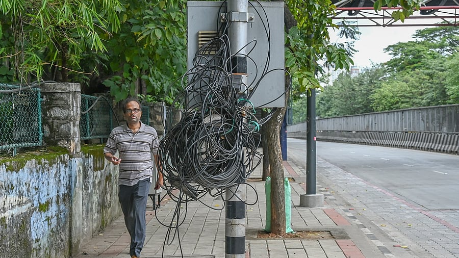 <div class="paragraphs"><p>A cluster of wires and cables entangled on a pole poses a risk to pedestrians. </p></div>