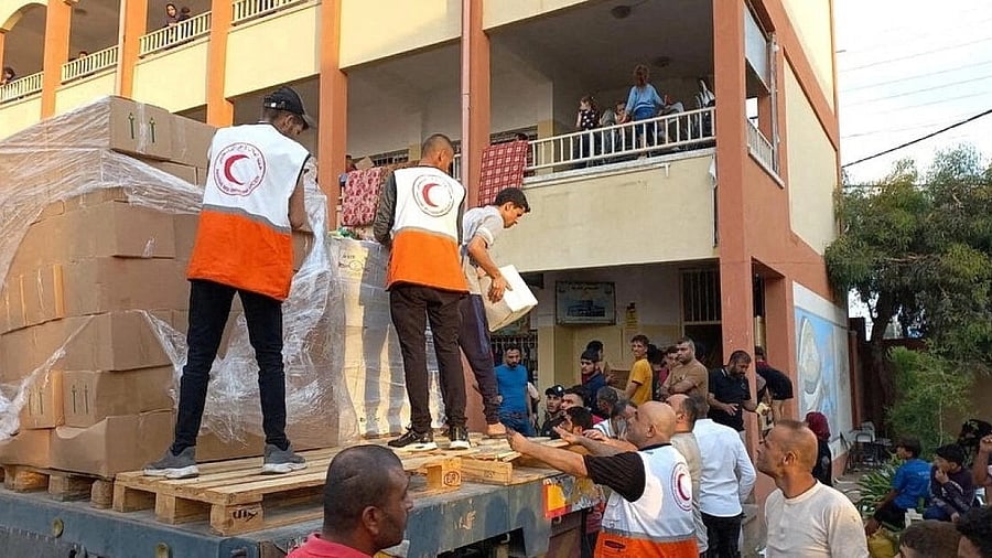 <div class="paragraphs"><p>Members of the Palestine Red Crescent Society distribute aid to people in Deir al-Balah, in the central Gaza Strip. </p></div>