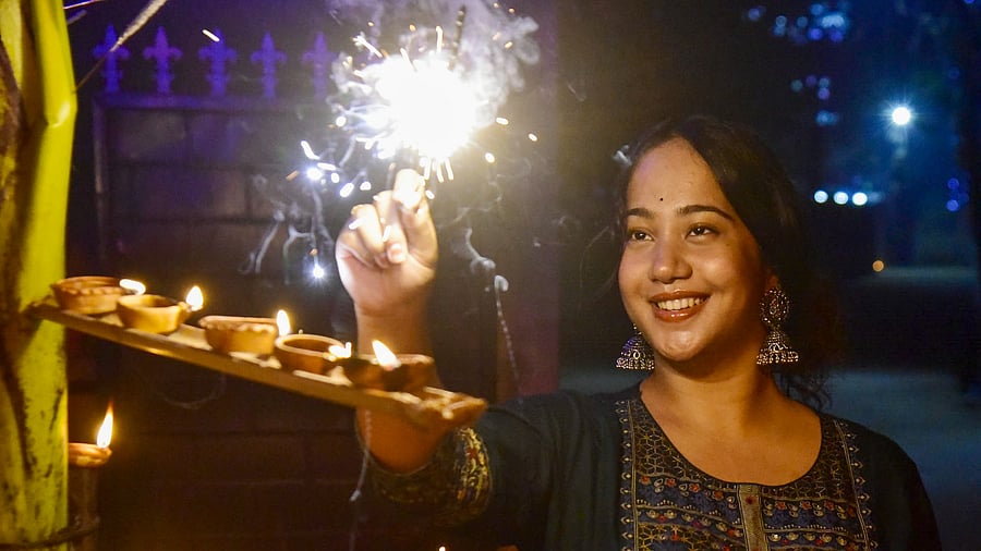 <div class="paragraphs"><p>A young woman burns sparkle to celebrate Diwali. </p></div>