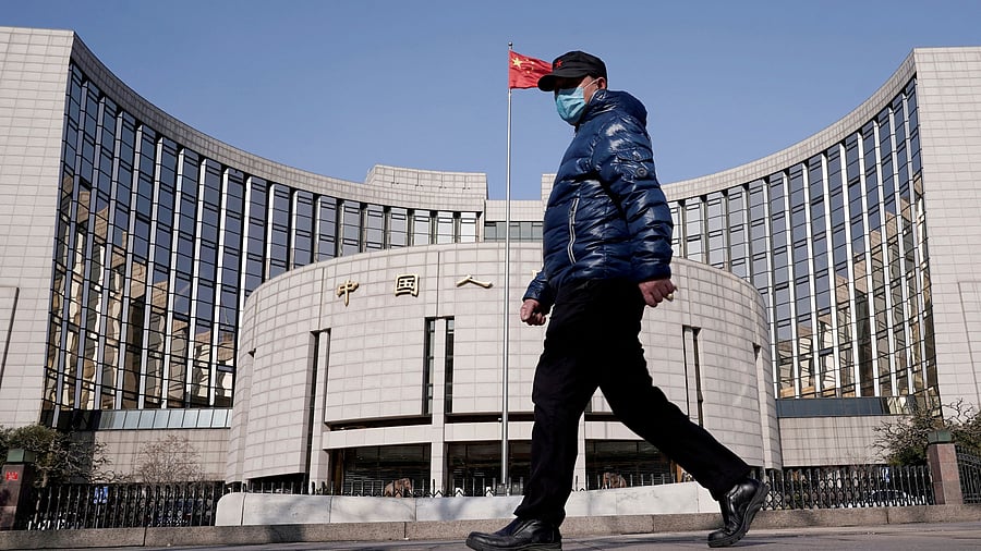 <div class="paragraphs"><p>A man wearing a mask walks past the headquarters of the People's Bank of China.</p></div>