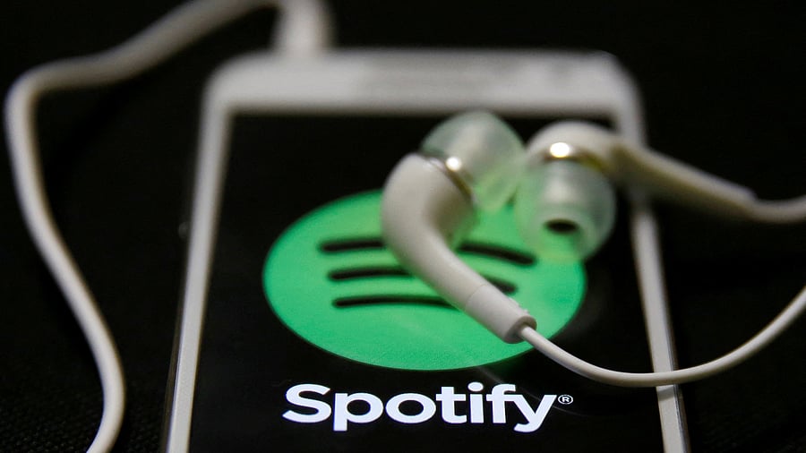 <div class="paragraphs"><p>Earphones are seen on top of a smart phone with a Spotify logo on it. </p></div>