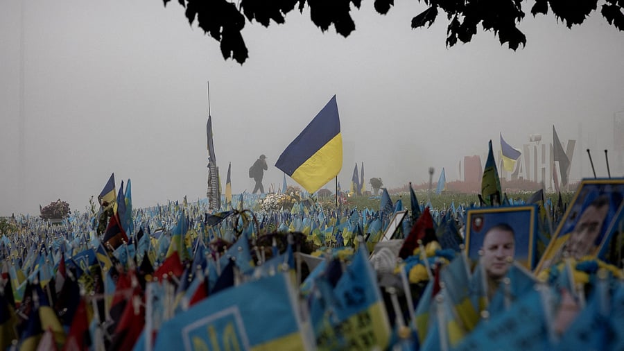 <div class="paragraphs"><p>A man walks past Ukrainian flags at a memorial site commemorating fallen soldiers in Independence Square on a foggy morning,</p></div>