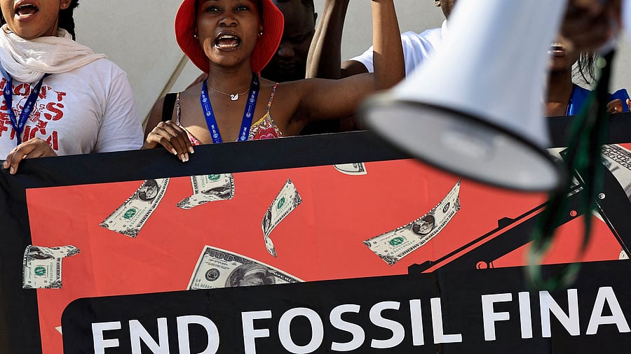 <div class="paragraphs"><p>Activists hold placards and shout slogans during a protest "Kick TotalEnemies Out of Africa" and against fossil fuels at the United Nations Climate Change Conference  in Dubai, United Arab Emirates.</p></div>