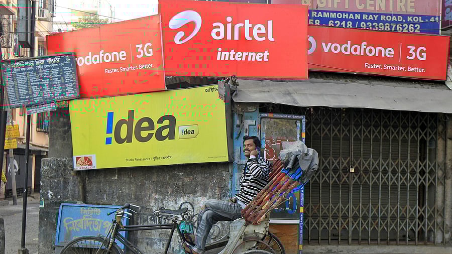 <div class="paragraphs"><p>A rickshaw puller speaks on his mobile phone as he waits for customers in front of advertisement billboards belonging to telecom companies in Kolkata, India, February 3, 2014. </p></div>