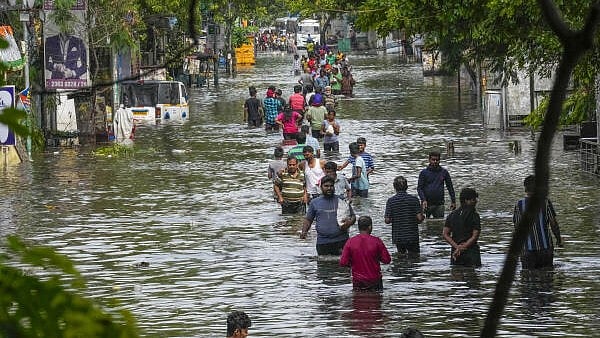 <div class="paragraphs"><p>People wade through a waterlogged road after heavy rainfall.</p></div>