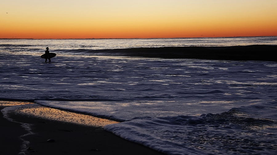 <div class="paragraphs"><p>A surfer is seen in silhouette as he heads out for waves in the Atlantic Ocean in Lido Beach, New York, US.  </p></div>
