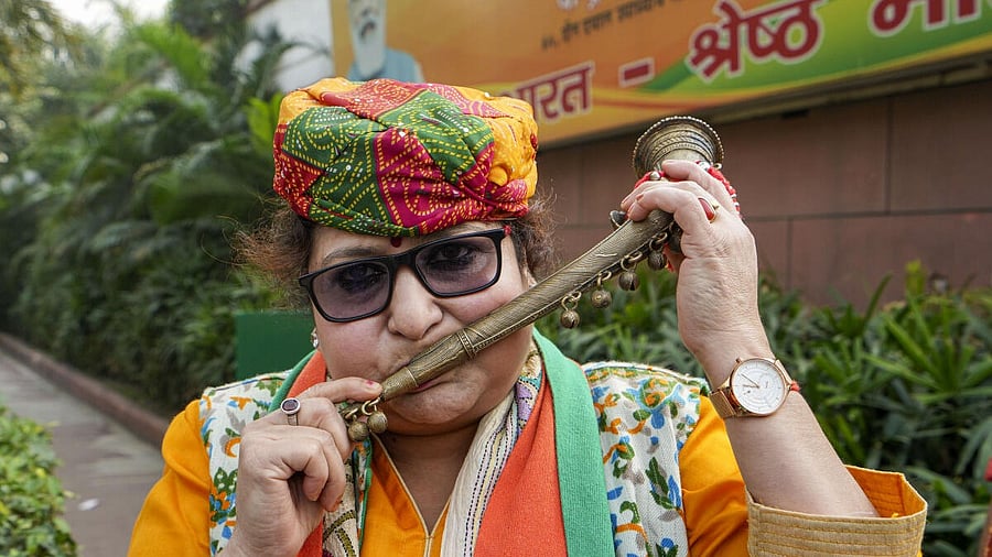 <div class="paragraphs"><p>A BJP worker celebrates the party's lead in Madhya Pradesh, Rajasthan and Chhattisgarh during counting of votes for the Assembly elections, at the party headquarters, in New Delhi, Sunday, Dec. 3, 2023.</p></div>