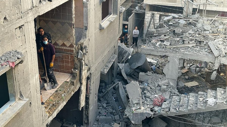 <div class="paragraphs"><p>Palestinians inspect the site of an Israeli strike on a house in Rafah in the southern Gaza Strip</p></div>
