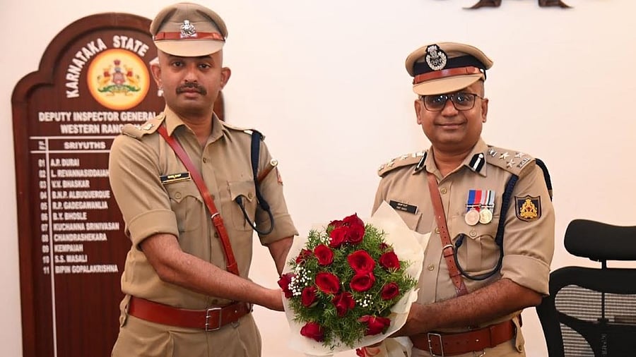 <div class="paragraphs"><p>Dakshina Kannada Superintendent of Police Ryshyanth C B hands over a bouquet to Amith Singh who took charge as the Deputy Inspector General of Police (DIGP) (Western Range) here in Mangaluru on Monday. </p></div>