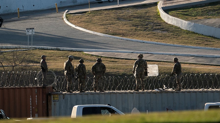 <div class="paragraphs"><p>US National Guard soldiers stand on shipping containers which are used as border fences on the bank of the Rio Grande river in Eagle Pass, Texas, US.</p></div>