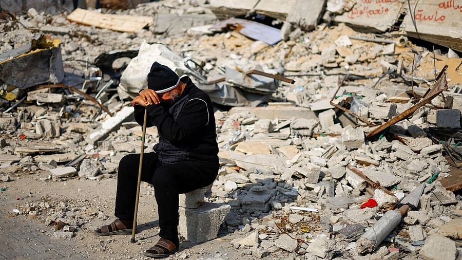 <div class="paragraphs"><p>Ziad Mansour, a neighbour of the Abu Aweidah family, sits next to writing painted on a wall amid the rubble of the family's house, which was destroyed in a deadly Israeli strike amid the ongoing conflict between Israel and the Palestinian Islamist group Hamas, in Rafah, Gaza Strip, January 9, 2024.</p></div>