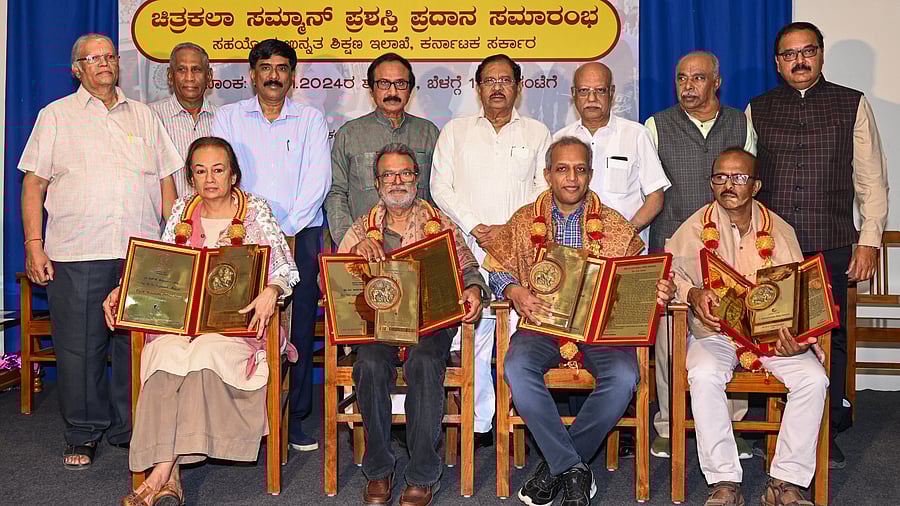 <div class="paragraphs"><p>The awardees (sitting, from left) Prof Vasudha Thozhur (H K Kejriwal Award), Prof B V Suresh (M Aryamurthy Award), L N Tallur (D Devaraj Urs Award) and B B Raghavendra, (Y Subramanya Raju Award) with their awards. G Parameshwar, Home minister and B L Shankar, President, Karnataka Chitrakala Parishath (KCP) in the background with faculty and staff from the KCP.</p></div>