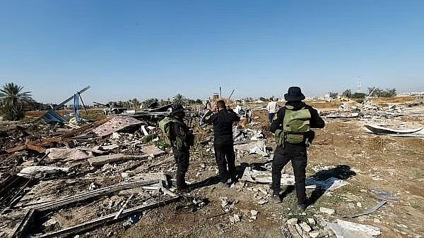 <div class="paragraphs"><p>Fighters of the Iraqi Kataib Hezbollah militia group and a man inspect the site of a US airstrike, in Hilla, Iraq.</p></div>