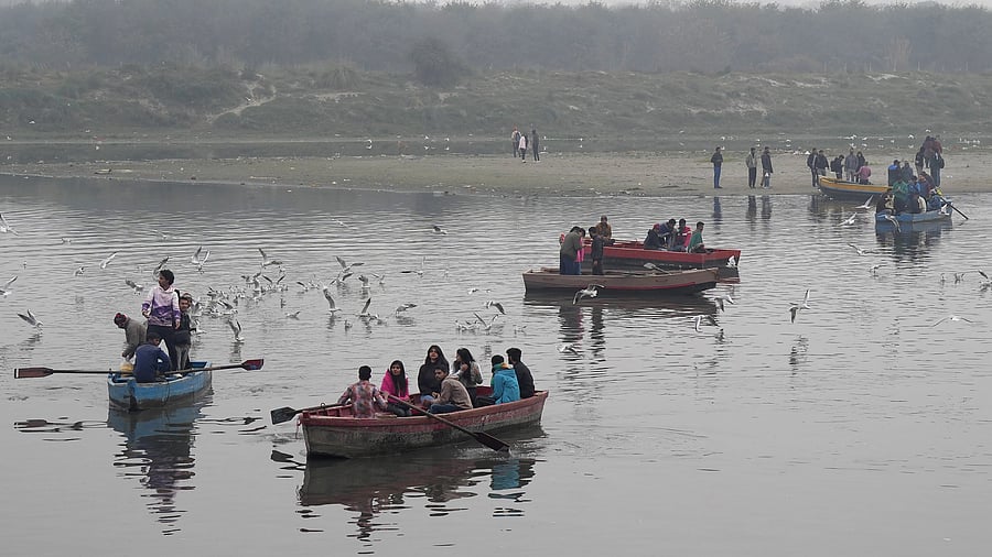 <div class="paragraphs"><p>People take a boat ride as a flock of migratory birds flies over the Yamuna river on a hazy winter morning, in New Delhi, Sunday, January 7, 2024. </p></div>