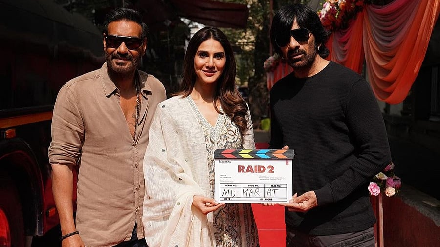 <div class="paragraphs"><p>Vaani Kapoor flanked by Ajay Devgn and Ravi Teja at the mahurat of <em>Raid 2</em>.</p></div>