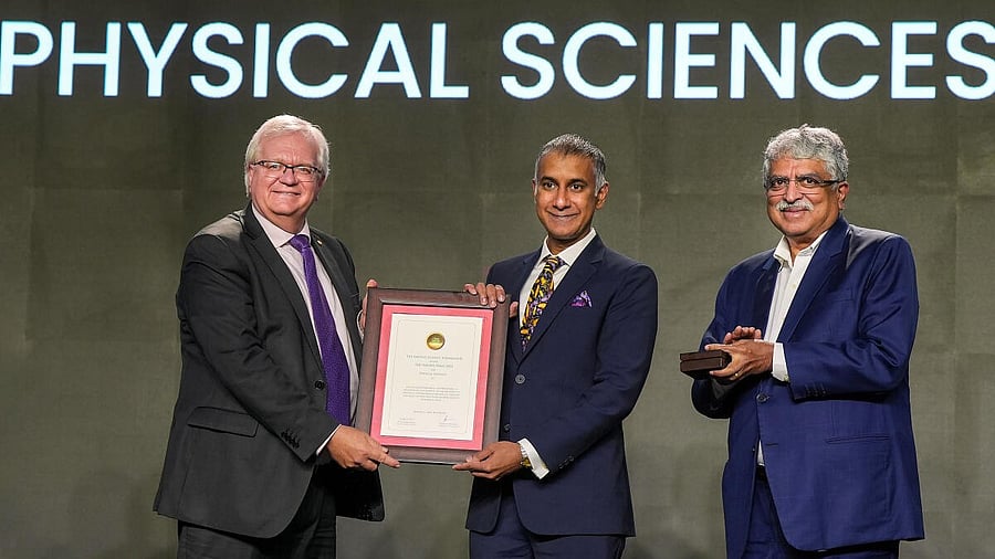 <div class="paragraphs"><p>Nobel Laureate Brian Schmidt hands over the Infosys Award to Mukund Thattai in Physical Sciences category as trustee Nandan Nilekani looks on during the Infosys Science foundation prize ceremony, in Bengaluru.</p></div>