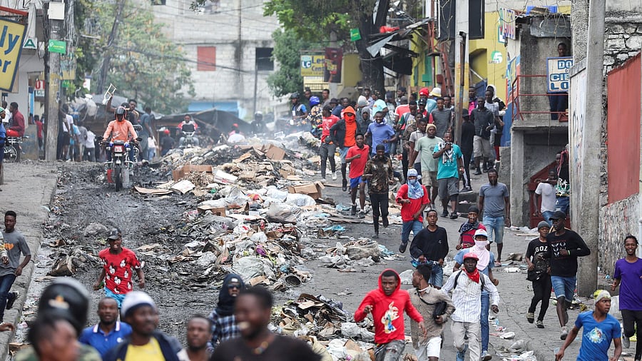 <div class="paragraphs"><p>Demonstrators run away from a barricade set up to block the route of Haitian National Police officers trying to get to the scene where agents of Haiti's BSAP, an armed environmental agency that has in recent years evolved into a paramilitary body, were killed in a shootout with security forces, in Port-au-Prince, Haiti.</p></div>