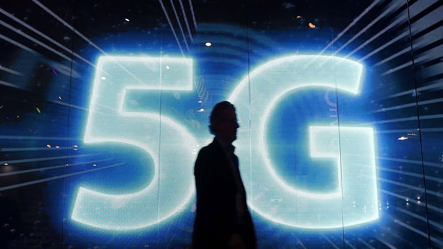 <div class="paragraphs"><p>A representative photo of the 5G logo, with a person in front of it.</p></div>