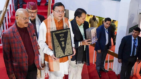 <div class="paragraphs"><p>Uttarakhand Chief Minister Pushkar Singh Dhami with others holds a copy of the Constitution of India, at Vidhan Sabha Bhawan, in Dehradun, Tuesday, Feb. 6, 2024. The Uniform Civil Code bill, which proposes uniform marriage, divorce, land, property and inheritance laws for all citizens irrespective of their religion in Uttarakhand, was tabled in the state assembly on Tuesday.</p></div>