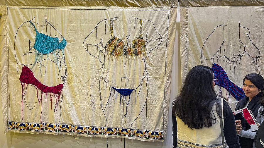 <div class="paragraphs"><p> Visitors look at an artwork on 'sexist stigma' created by artist Mayuri Chari, at the India Art Fair in New Delhi.</p></div>