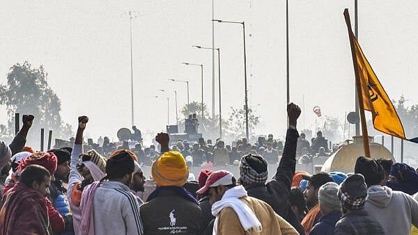 <div class="paragraphs"><p>Farmers raise slogans in front of security personnel guarding at the Punjab-Haryana Shambhu border during their 'Delhi Chalo' protest, near Patiala district, Friday, February 16, 2024.</p></div>